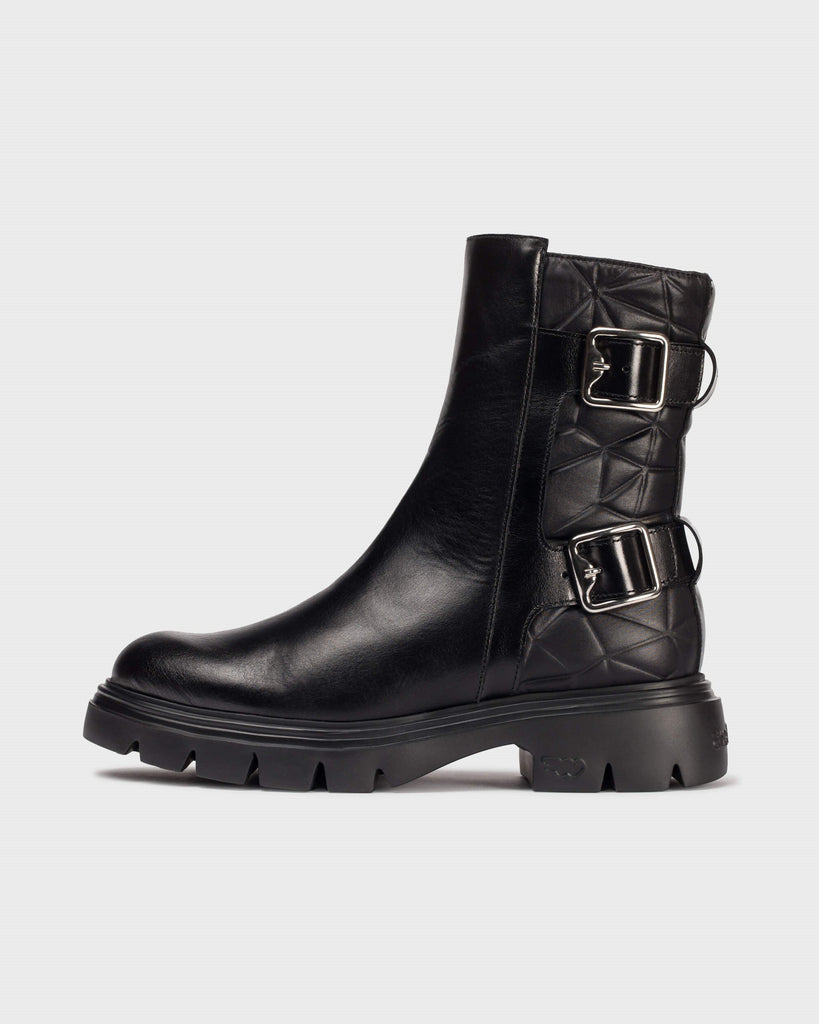 Black leather boot with buckles on a light gray background