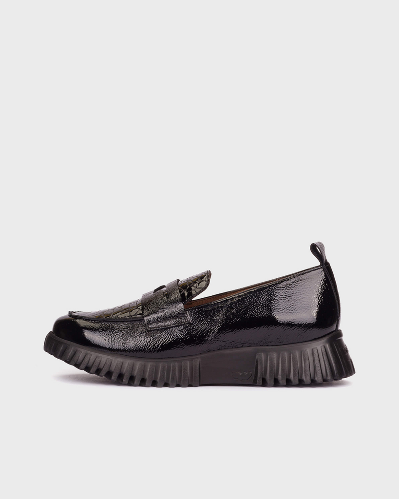 Black slip-on sneaker on a white background