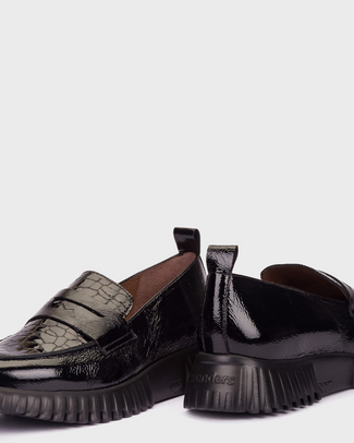 Black slip-on sneaker on a white background