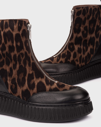 A platform ankle boot featuring a brown and black leopard print upper with solid black leather side panels, a black platform sole, and a side zipper.