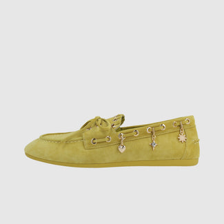 Green loafer shoe with charms on a light gray background
