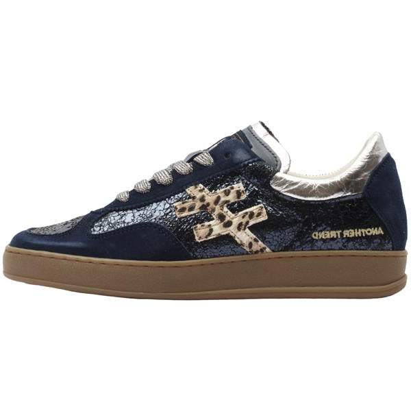 A navy blue low-top sneaker with textured metallic silver overlays, a beige leopard-print cross logo, and a gum brown sole, shown from a side profile on a white background.