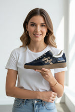 Load image into Gallery viewer, A navy blue low-top sneaker with textured metallic silver overlays, a beige leopard-print cross logo, and a gum brown sole, shown from a side profile on a white background.
