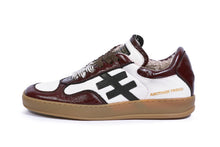 Load image into Gallery viewer, A low-top sneaker by Another Trend featuring dark brown and white leather panels, a black geometric side logo, brown laces, and a tan gum sole.
