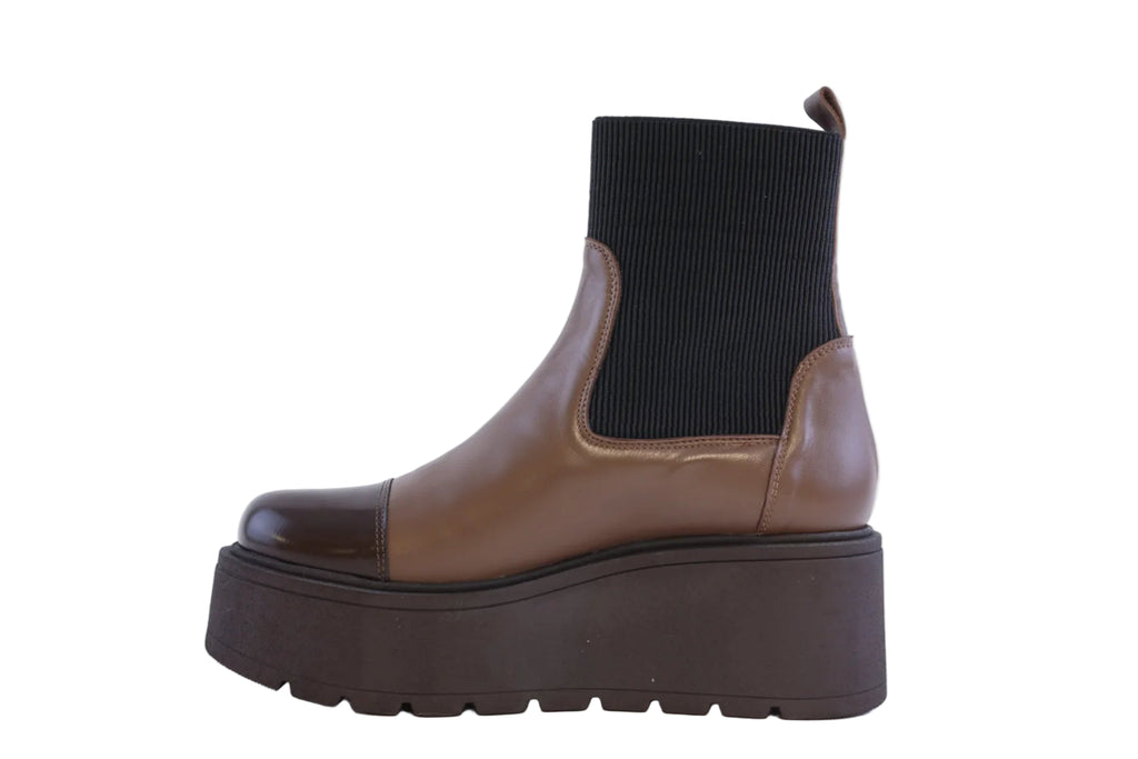 Brown platform boot with black sock on a white background