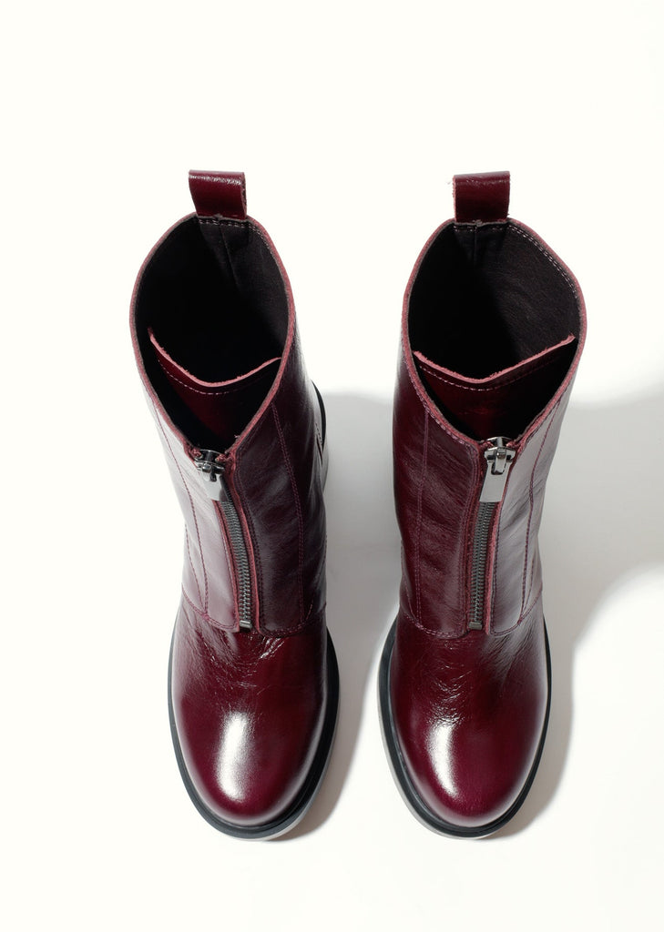 Pair of maroon boots with zippers on a white background