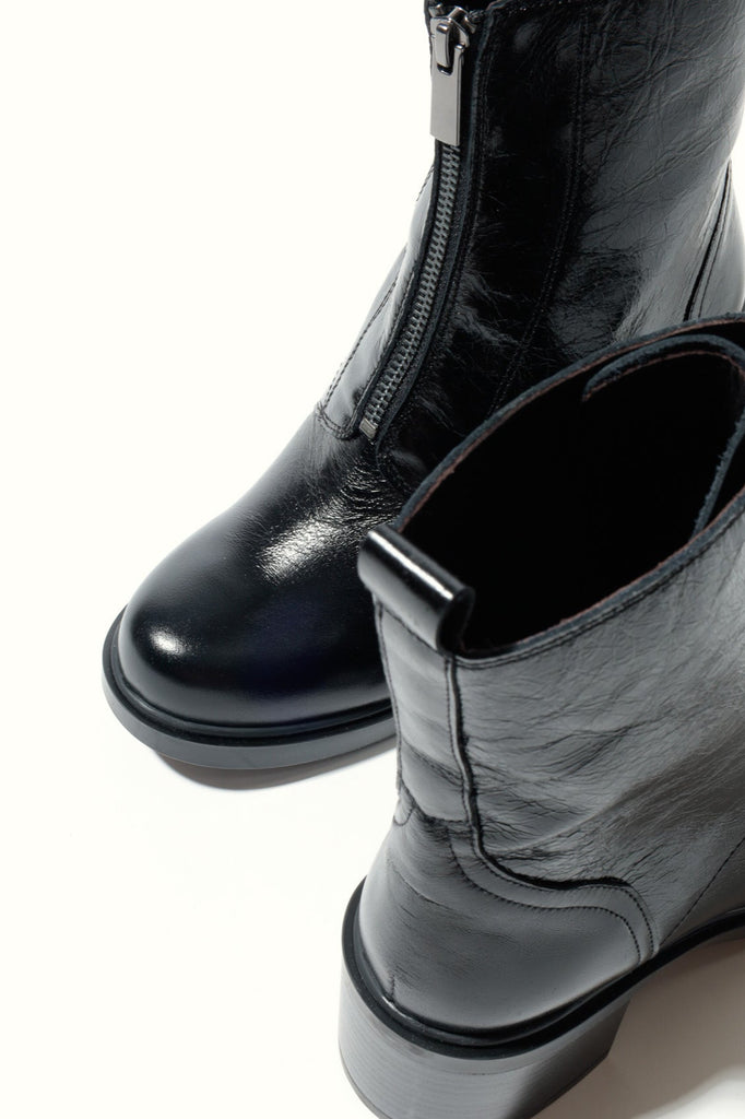 Black leather boots with a zipper on a white background