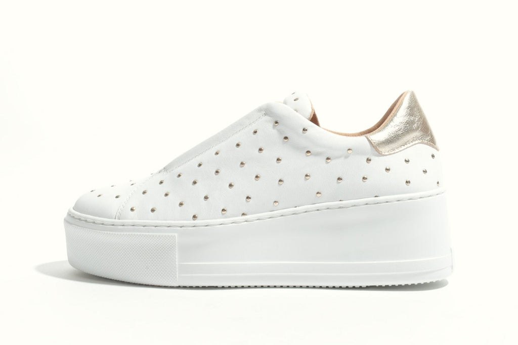 White sneaker with gold accents on a white background