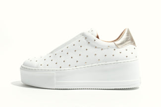 White sneaker with gold accents on a white background