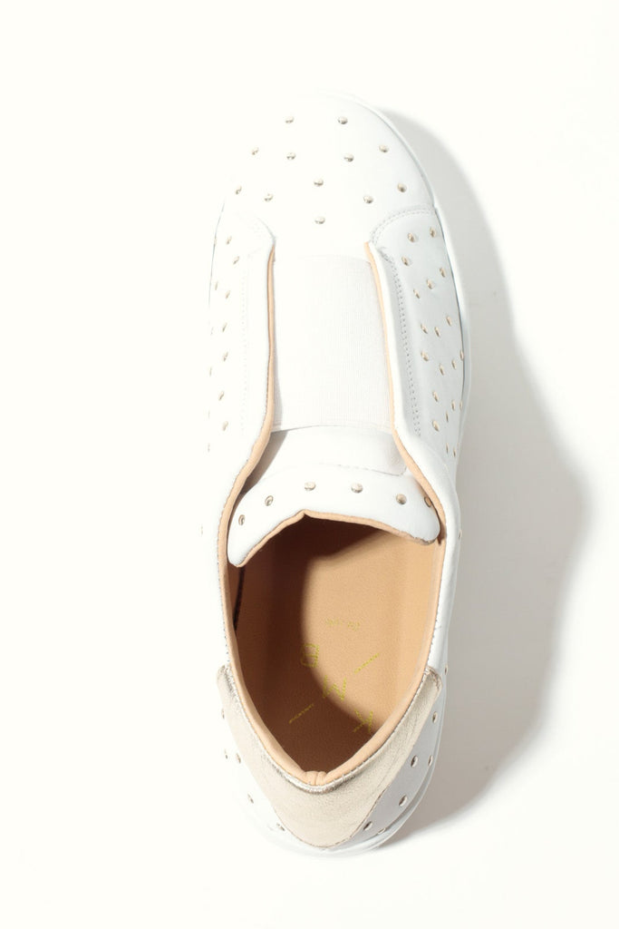 White shoe with a beige sole on a white background