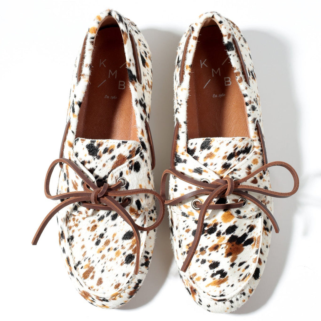 Pair of patterned loafers with brown laces on a white background