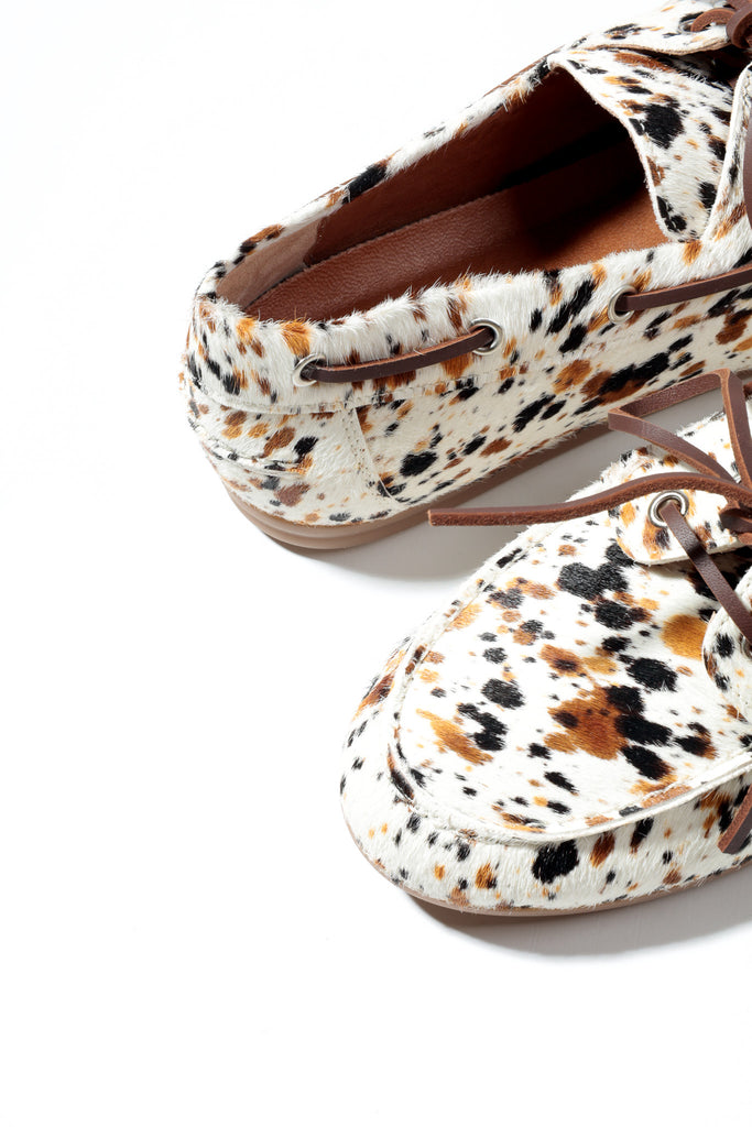 Pair of animal print loafers on a white background