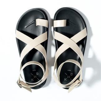 Beige sandal with black sole on a white background