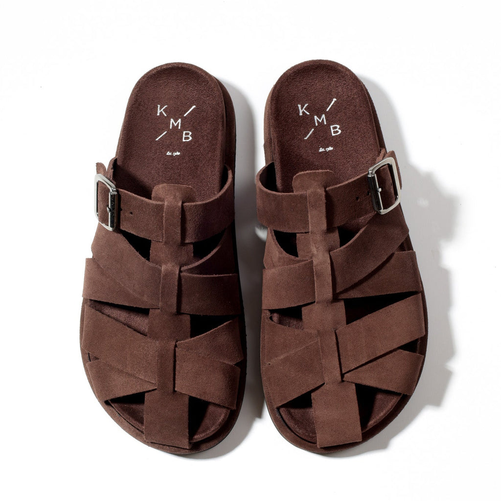 Pair of brown sandals with 'KMB' branding on a white background