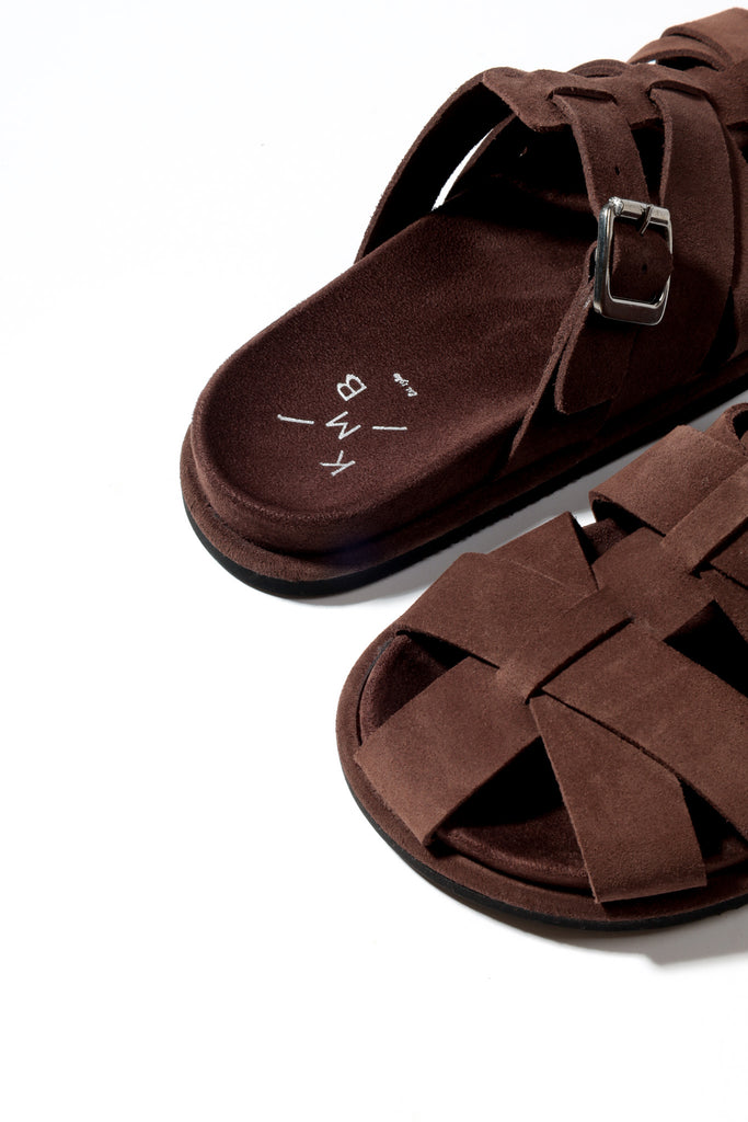 Brown sandals with criss-cross straps on a white background