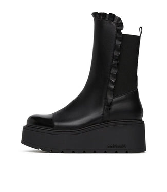 Black platform boot with ruffled detail on a white background