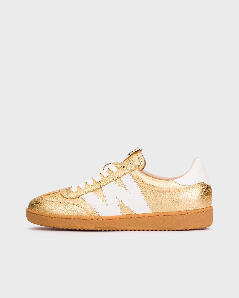 Gold and white sneaker on a light gray background