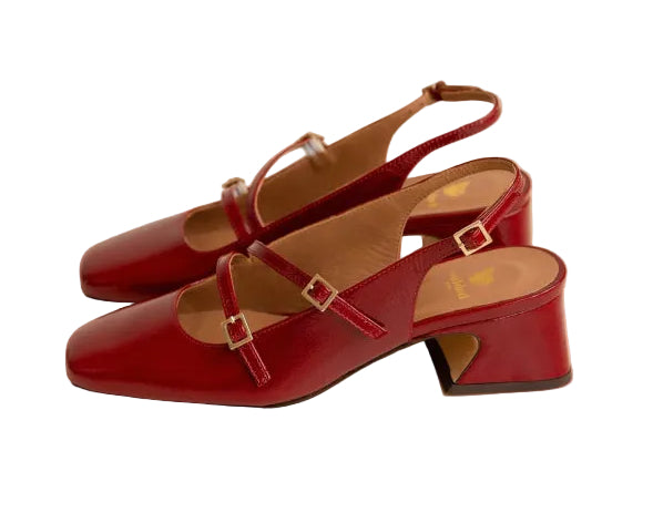 Red high-heeled shoes with a strap on a beige background