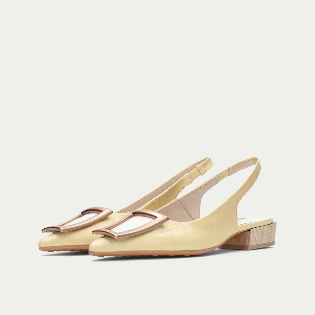 Pair of light yellow slingback shoes on a white background
