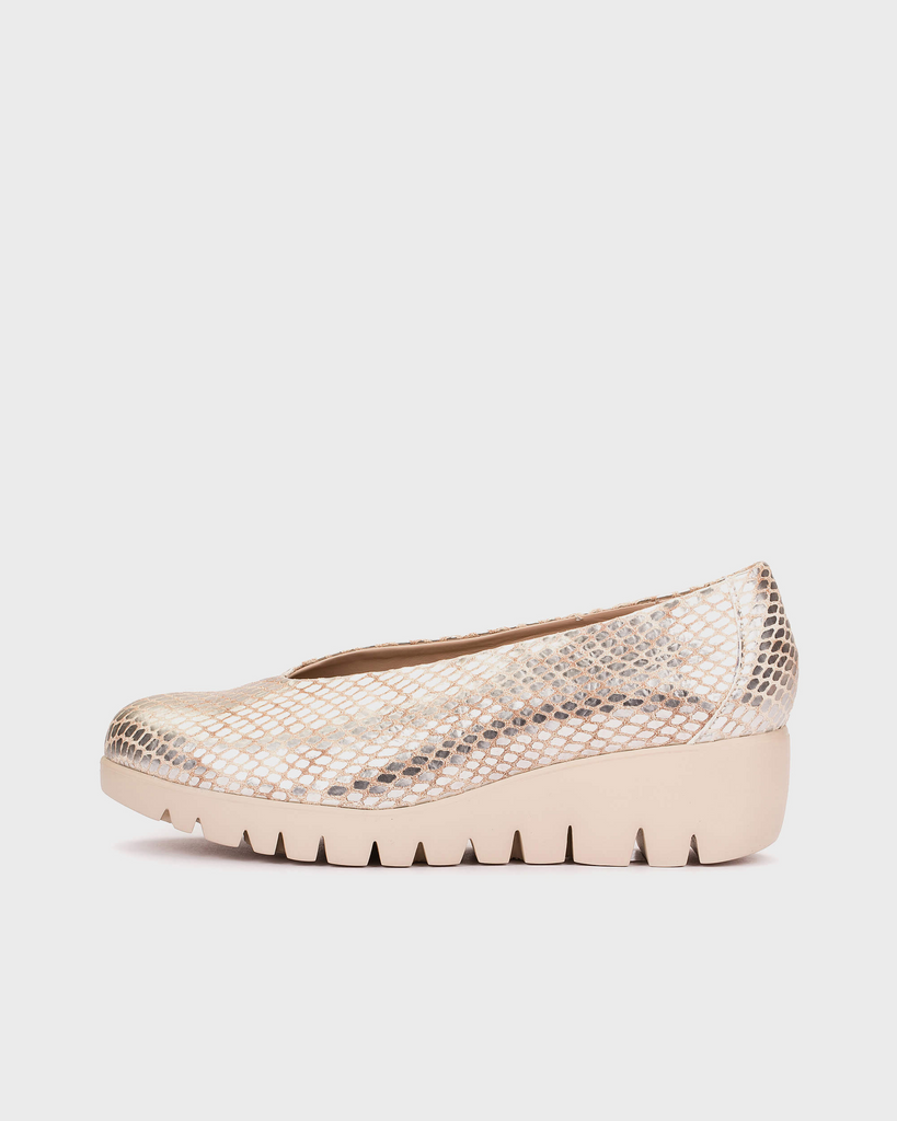 gold wedge shoe with snake print pattern on a light gray background