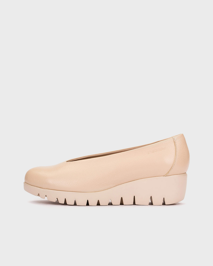 Beige wedge shoe on a light gray background