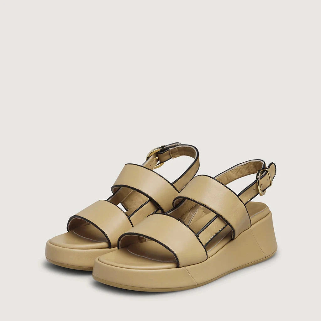 Pair of beige sandals on a light gray background