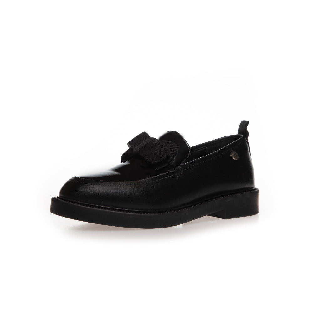 A single black leather loafer with a decorative bow detail across the vamp and a low block heel, shown from a side profile on a white background.