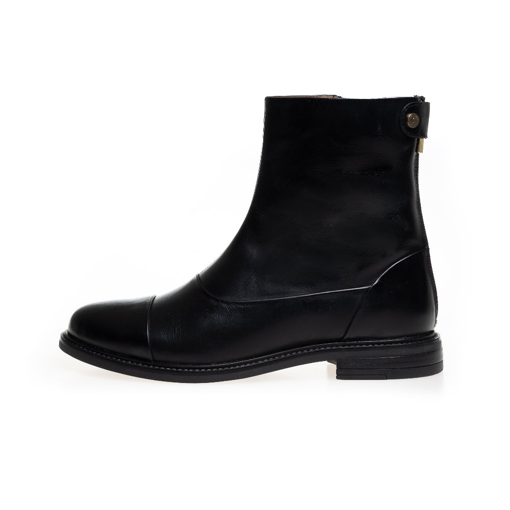A black leather ankle boot with a low block heel, a cap toe, and a small gold-tone button detail on the back, shown from a side profile on a white background.