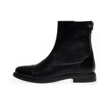 Load image into Gallery viewer, A black leather ankle boot with a low block heel, a cap toe, and a small gold-tone button detail on the back, shown from a side profile on a white background.
