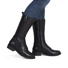 Load image into Gallery viewer, Black riding boots worn with blue jeans on a white background
