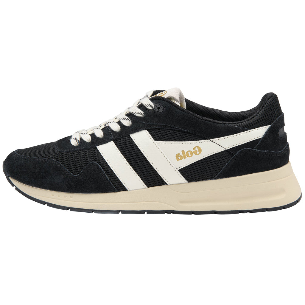 A black suede and mesh sneaker with white side stripes, white laces, and a cream-colored midsole and heel tab. The side of the shoe features the brand name 'Gola' in gold lettering.