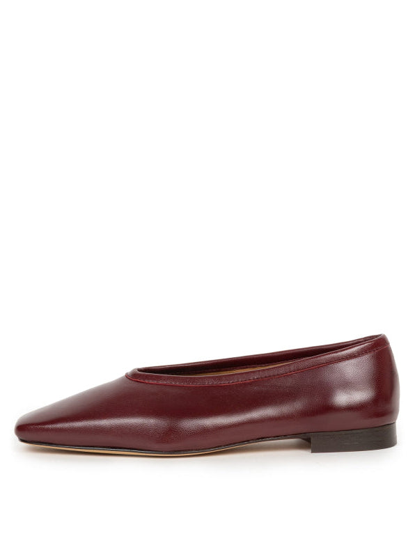 A single burgundy leather ballet flat shoe with a pointed toe and low heel, shown in profile against a plain white background.