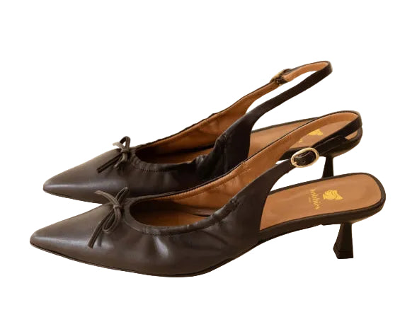 Pair of black high-heeled shoes on a beige background