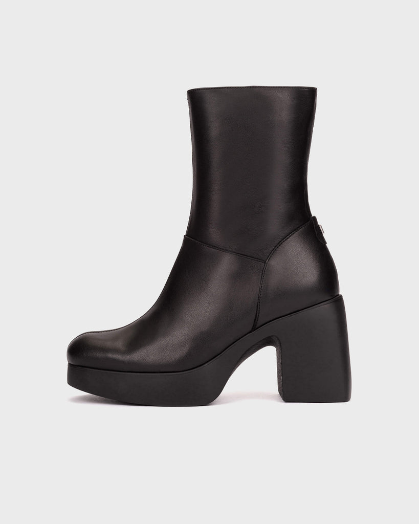 A black leather ankle boot with a chunky block heel and platform sole, shown from a side profile on a light gray background.