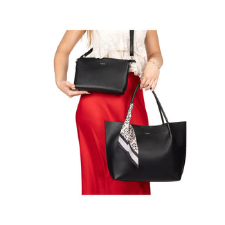 Black handbags held by a person wearing a red skirt on a white background