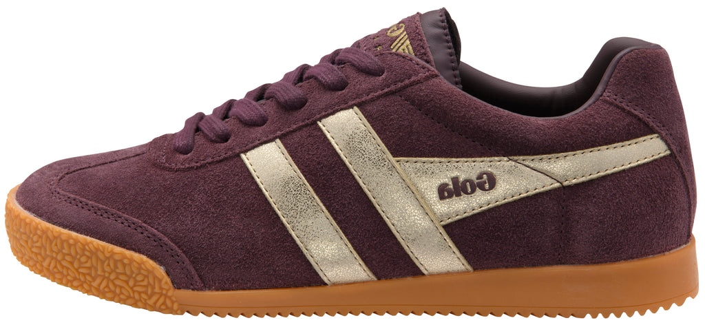 A low-top Gola sneaker in dark purple suede with metallic silver side stripes and a brown gum sole, shown from a side profile on a white background.
