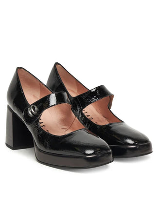 Black patent leather shoe with a block heel on a white background