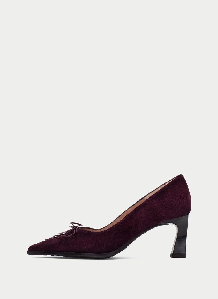 A single dark plum purple suede pump with a pointed toe and a chunky black block heel, shown in profile against a light gray background.