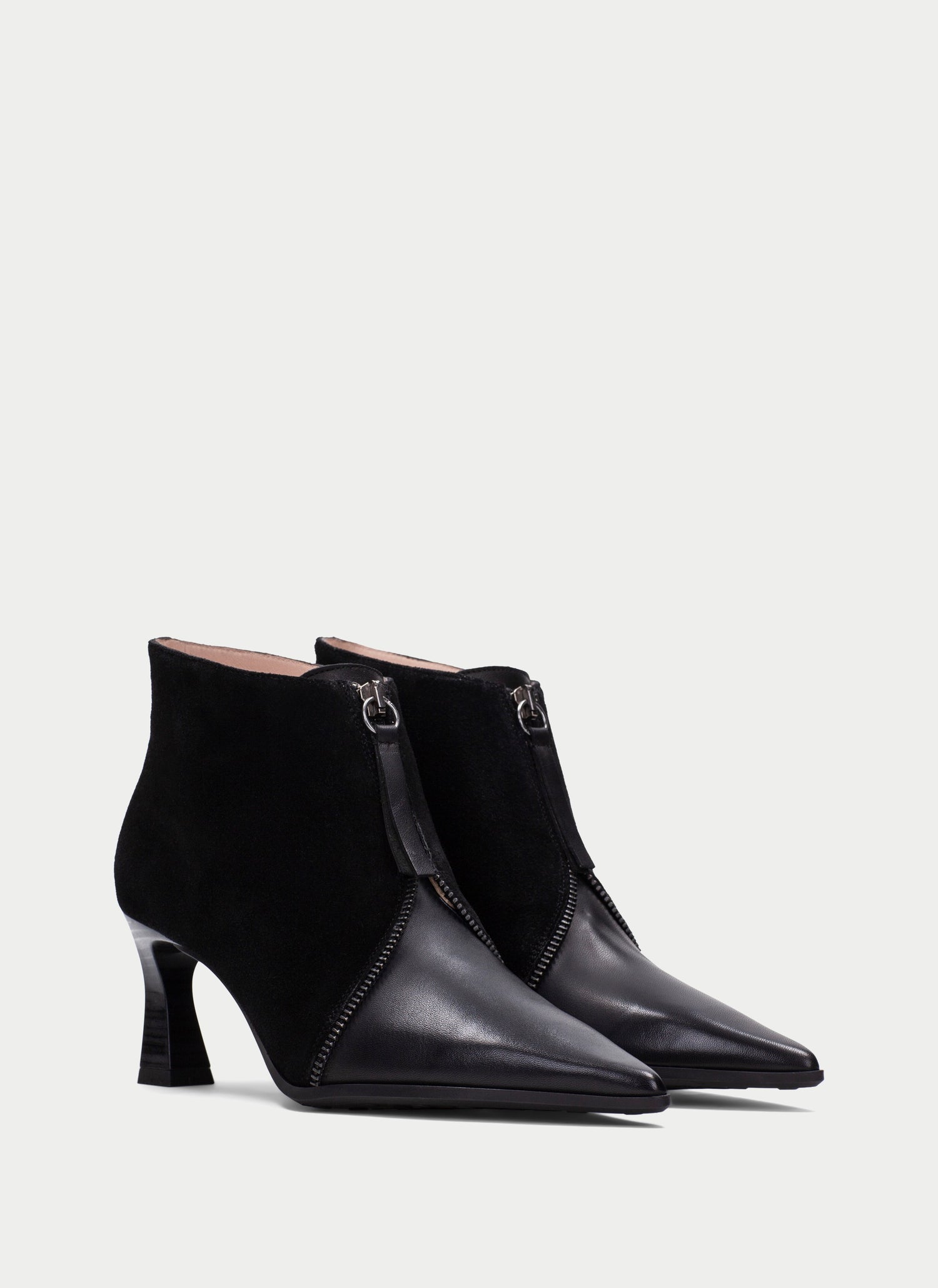 A pair of black pointed-toe ankle boots with a mix of matte suede and smooth leather panels, featuring a mid-height block heel and a side zipper with a metal ring pull, shown against a light gray background.