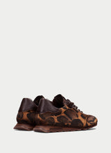 Load image into Gallery viewer, A pair of low-top lace-up sneakers featuring a brown and black leopard print pattern with dark brown leather heel panels, shown from a side profile against a light gray background.
