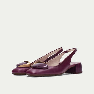 Pair of purple slingback shoes with a gold accent on a light gray background