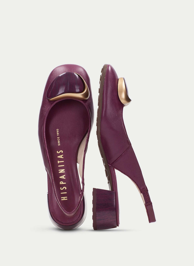 Purple shoes with gold accents on a light gray background