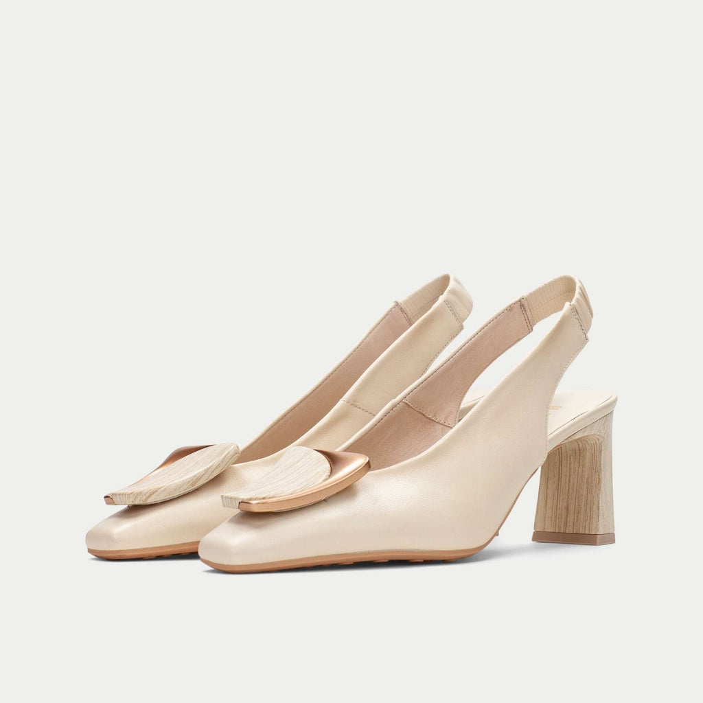 Pair of beige high-heeled shoes on a light gray background