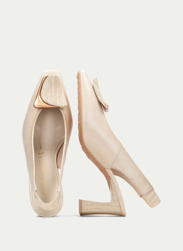 Pair of beige high-heeled shoes on a light gray background