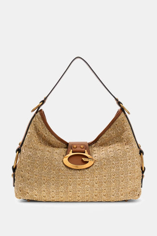 Person holding a beige handbag with a gold clasp against a neutral background