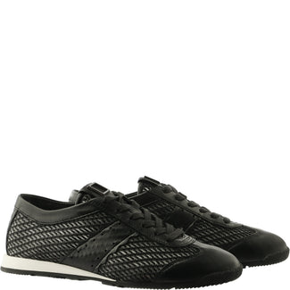 Black sneaker with textured side panel on a white background