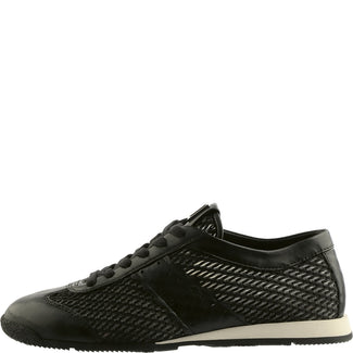 Black sneaker with textured side panel on a white background
