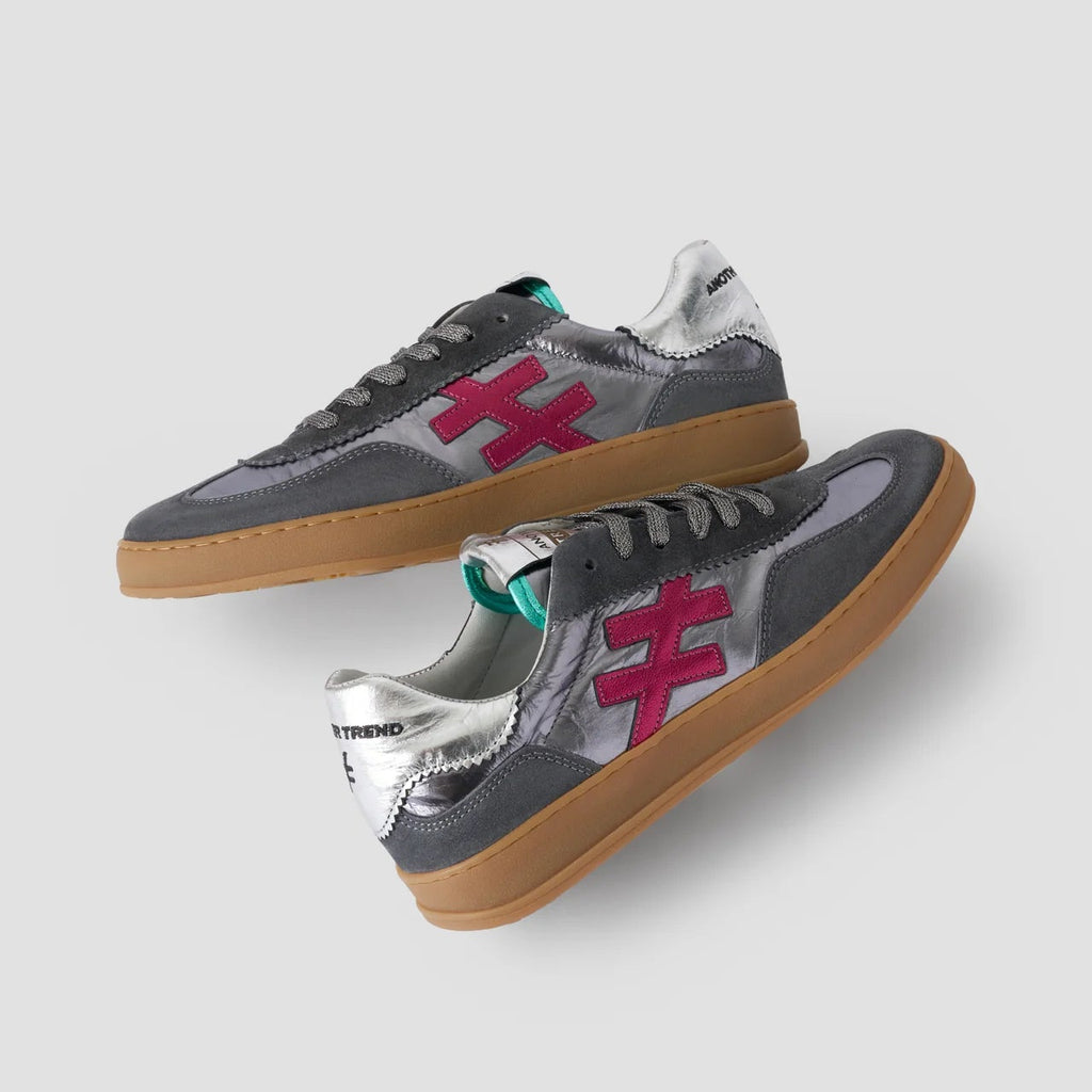 Gray sneakers with red logo and brown soles on a light gray background