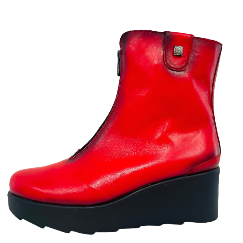 Red ankle boot with black sole on a white background