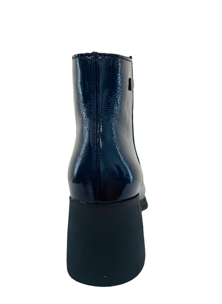 Black ankle boot with a glossy finish on a white surface